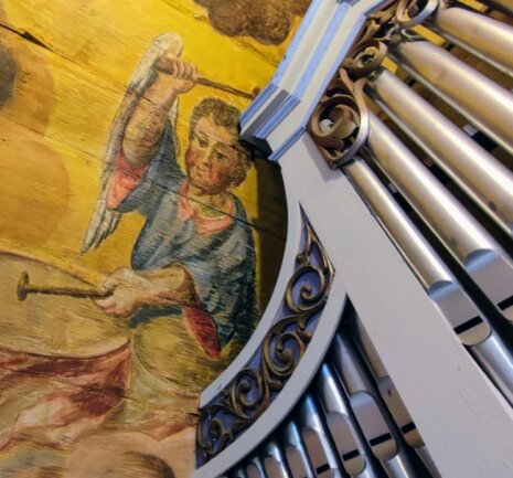 Neben den Pfeifen der Trampeli-Orgel ist ein musizierender Engel zu sehen. Das ist ein Teil der üppigen Ausmalungen in der Kirche.