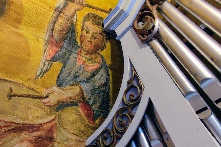 Neben den Pfeifen der Trampeli-Orgel ist ein musizierender Engel zu sehen. Das ist ein Teil der üppigen Ausmalungen in der Kirche.