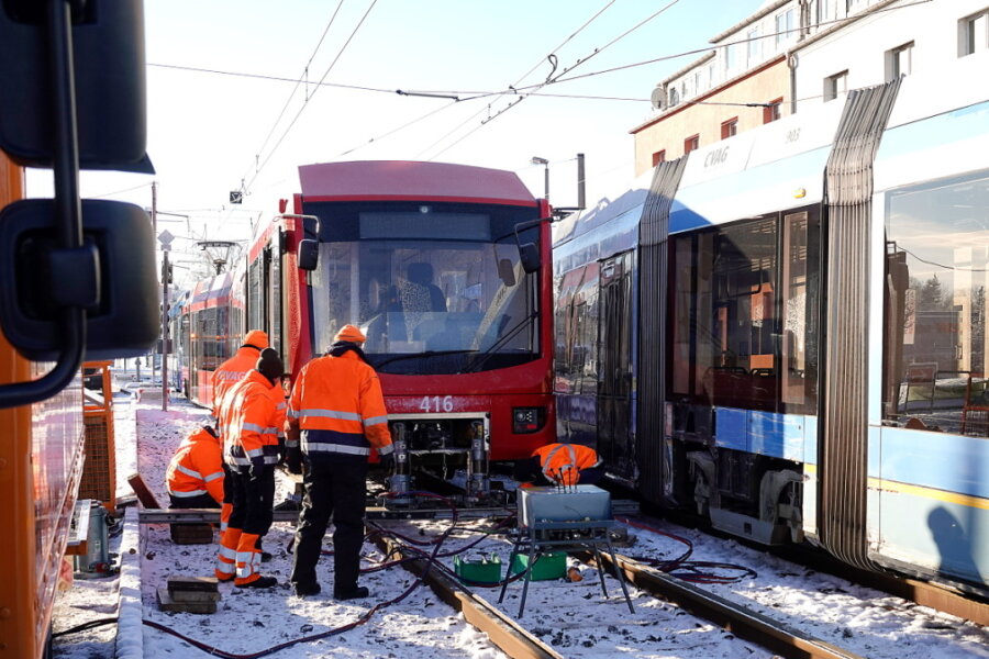 Bei frostigen Temperaturen brachten Mitarbeiter der CVAG in Altchemnitz die kollidierten Bahnen (hier in Rot die Bahn aus Stollberg) im Laufe des zweiten Feiertags wieder auf die Schienen. Der Unfall hatte sich am Abend zuvor zu später Stunde ereignet. 