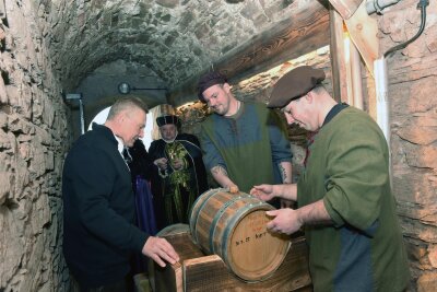 Augustusburg: Weyberkuss, der Whisky mit der besonderen Note - Im Brunnenhaus von Augustusburg ist ein spezieller Whisky eingelagert worden. Wolfgang Lückert (l.) hatte die Idee dazu, die Knechte Franz Vieweger (r.) und Tim Laßner trugen das Fässlein in den Ochsenschuppen.