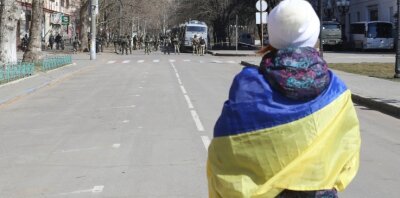 Aus Deutschland, Russland und der Ukraine - Eine Freundschaft in schwieriger Zeit - Eine Frau mit ukrainischer Fahne steht bei einer Demonstration gegen die russische Besatzung in Cherson. 
