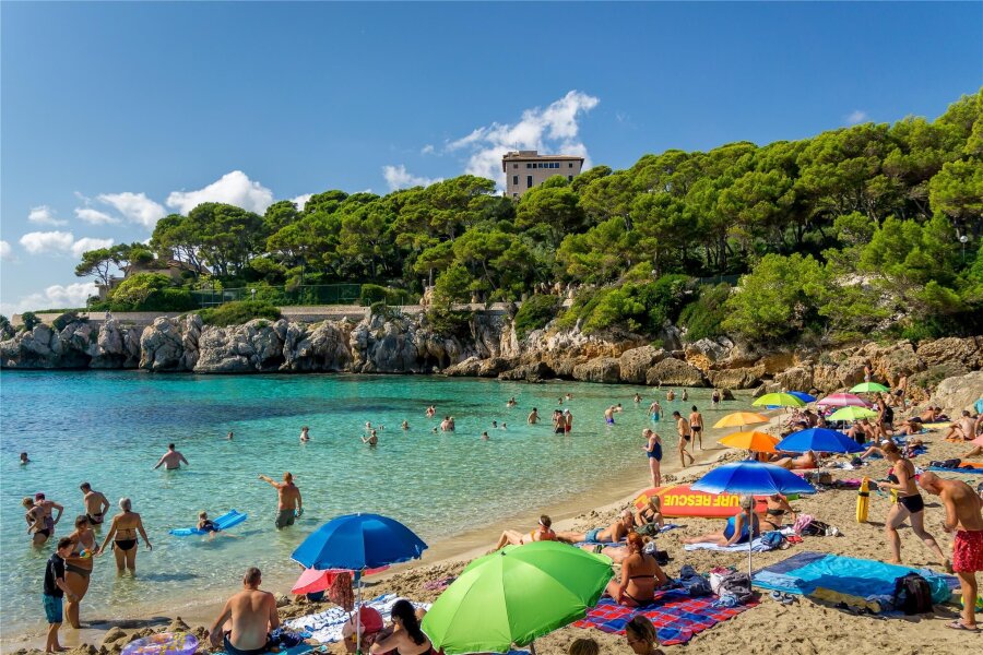 Ausgerechnet zur Urlaubszeit: Mallorca sieht neue Corona-Welle mit Flirt-Variante - Corona grassiert auf Mallorca. Ob auch der Strand dieser Bucht bei Cala Rajada Übertragungspunkt ist, hängt wohl allein an der Touristendichte. Immerhin zählt man Großveranstaltungen wie das jüngst stattgefundene Mallorca Festival zu Übertragungsschleudern für neue Varianten.