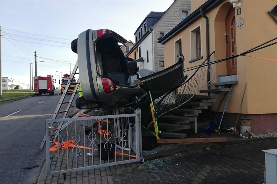 Auto kracht in Altmittweida in Vorgarten - zwei Verletzte - Der Renault blieb nach dem heftigen Einschlag auf der Seite auf einem Zaun liegen.