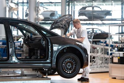 Auto-Professor über VW-Produktion in der Gläsernen Manufaktur: "Weder kostendeckend noch effizient" - Ein Mitarbeiter von Volkswagen arbeitet in der Gläsernen Manufaktur in der Endmontage am Frontende eines VW ID.3. 