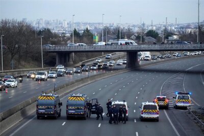 Autobahnblockaden: Auch Frankreichs Bauern erhöhen den Druck auf die Regierung - Polizeikräfte blockieren den Verkehr auf einer Autobahn, während Landwirte nördlich von Paris demonstrieren.