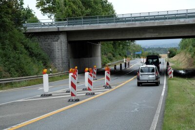 Autobahnbrücke bei Reichenbach ist noch immer eine Baustelle - Geleitet durch rot-weiße Warnbaken und gelbes Fahrbahn-Markierungsband, schlängelt sich der Verkehr auf der B 94 unter der Autobahnbrücke bei Reichenbach hindurch.