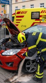 Autos in Rochlitz kollidiert - Ein Feuerwehrmann bindet ausgelaufene Schadstoffe des im Unfall verwickelten Pkws (Ford).