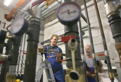 Bad Schlema: Heizen mit Geothermie verzögert sich - Mike Kittler (links) und Steffen Nürnberger haben die moderne Heizungsanlage in der Schillerschule installiert.