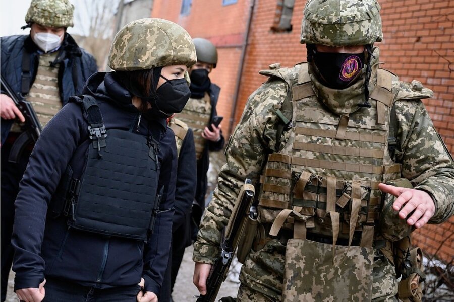 Mit Schutzhelm und Maske: Annalena Baerbock (vorn links) verschafft sich in der Ostukraine ein Bild von der Lage. 