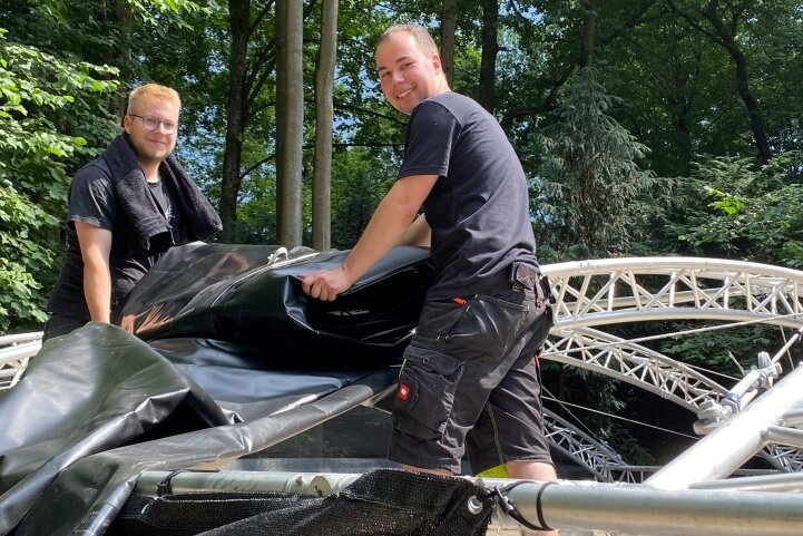 Leon Franke (l.) und Moritz Rotter am Montag beim Aufbau der Waldbühne in Börnichen. 