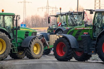Bauernproteste in Sachsen: Landwirte warten auf den Donnerstag - Traktoren vor einer Autobahnauffahrt. Sachsens Landwirte planen für die nächsten Tage keine flächendeckenden Straßenblockaden.