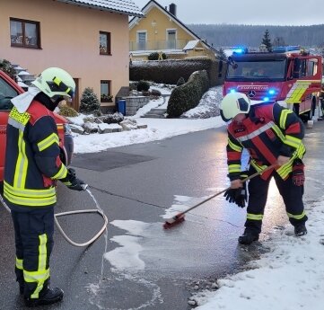 Die Feuerwehr Beierfeld beseitigt An der Dürre Schönberg eine lange Ölspur. 