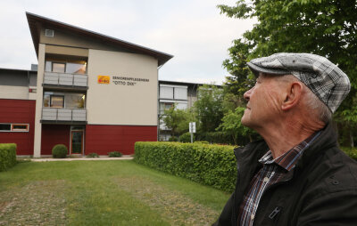 Der 84 Jahre alte Rentner Alfons Blum steht vor dem Seniorenpflegeheim Otto Dix. In diesem Heim wohnt seine Ehefrau. Er gab am 16.05.2020 bei einer Anti-Corona-Demo ein bewegendes Interview, da er seit mehreren Wochen seine Frau Gisela wegen der Corona-Einschränkungen nicht mehr sehen kann. 