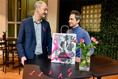 Beim Chemnitzer Shopping Day sehen dieses Jahr alle pink - Galerie Roter Turm-Manager Jörg Knöfel (li.) und Innenstadtkoordinator Sven Hertwig mit den pinkfarbenen Ansteckern und Einkaufstüten, die zum Shopping Day verteilt werden sollen.