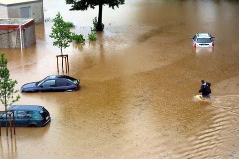 Beim Flutschutz kehrt der Schlendrian zurück - Unwetter und Hochwasser 2002 in Aue. Ein Autobesitzer versucht sein Fahrzeug zu erreichen, bevor es von den Fluten endgüldig geschluckt wird.