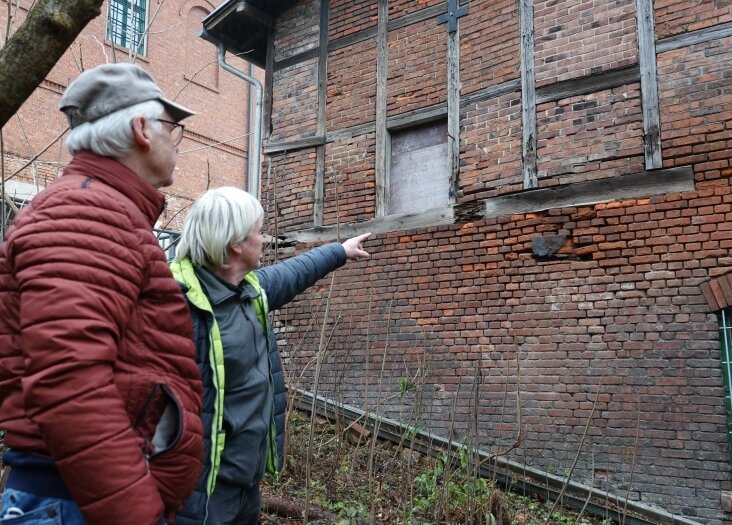 Ulrich Schildbach (links) und Helmar Sittner begutachten die Schäden an der hinteren Wand des denkmalgeschützten Gebäudes.