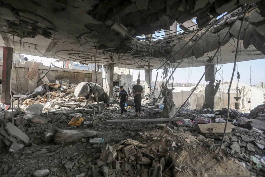 Berichte: Hamas für Verhandlungen über Waffenruhe in Kairo - Palästinenser stehen in den Trümmern eines Hauses nach einem israelischen Luftangriff, bei dem mehrere Menschen getötet wurden.