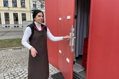 Beschädigte Marktbuden auf Zwickauer Neumarkt: Stadt gibt Reparatur in Auftrag - Kathrin Steinig zeigt die beschädigte Tür des Marktstandes der Fleischerei Wrobel.