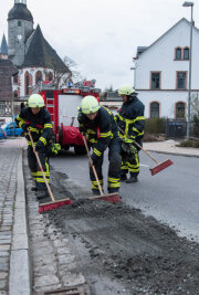 Beton verloren: Wehr im Einsatz - Mit Besen und Schaufel ist am Donnerstagabend die Rochlitzer Feuerwehr an der Leipziger Straße, Höhe Burgstraße, im Einsatz gewesen.