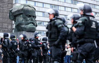 Bewährungsstrafe für Hitlergruß bei Demo in Chemnitz - Polizisten sichern eine Demonstration der rechten Szene vor dem Karl-Marx-Monument am 27. August. Auf dieser Demo zeigte ein 49-Jähriger den Hitlergruß, nun wurde er verurteilt.