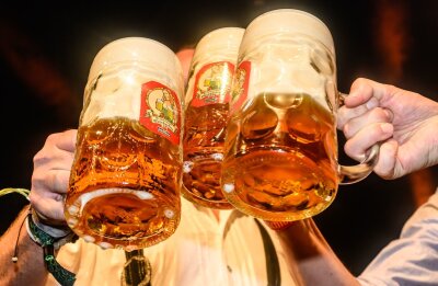 Bierabsatz rückläufig - Branche für 2024 zuversichtlich - Mit Maßkrügen wird am traditionellen Fassbieranstich zum Dresdner Oktoberfest angestoßen.