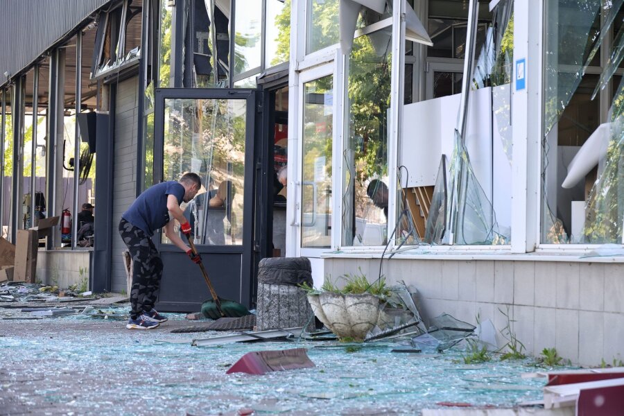 Bilder des Tages vom 02.05.2024 - Die Spuren der Zerstörung beseitigen: Ein Mann kehrt in Odessa die Glasscherben eines Schaufensters zusammen, das bei einem russischen Raketenangriff zu Bruch gegangen ist.