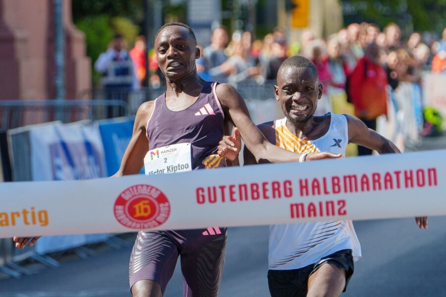 Bilder des Tages vom 05.05.2024 - Im letzten Moment gleichauf: Victor Kiptoo (l, Uganda) und Benson Nzioki (Kenia) kommen beim Gutenberg-Halbmarathon in Mainz zur gleichen Zeit ins Ziel und teilen sich nach derzeitigem Stand den ersten Platz.