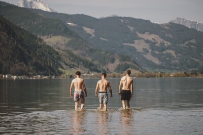 Bilder des Tages vom 07.04.2024 - Diese drei Männer brauchen erstmal eine Abkühlung - außergewöhnlich hohe Temperaturen gab es dieses Wochenende auch im österreichischen Zell am See.