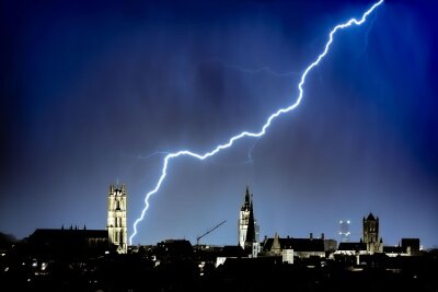 Bilder des Tages vom 09.04.2024 - Ein Blitz entlädt sich über der St.-Bavo-Kathedrale im belgischen Gent. Seit mehr als 1000 Jahren ist sie das Wahrzeichen der zweitgrößten Stadt des Landes.
