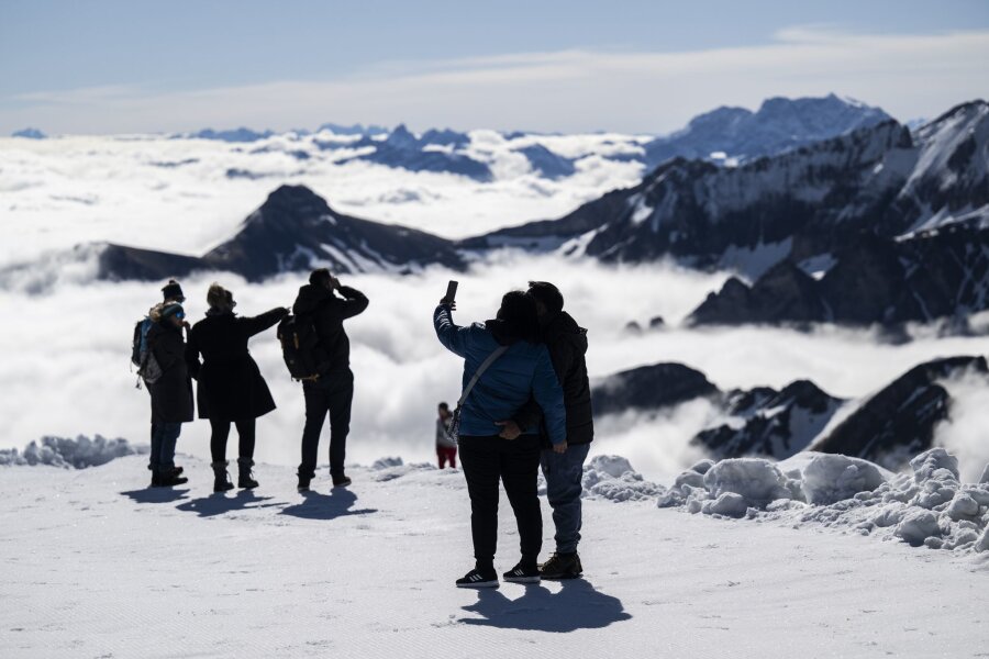 Bilder des Tages vom 09.05.2024 - Über den Wolken.. Touristen genießen das Wetter auf dem Berg Chäserrugg in der Schweiz. Auf dem Gipfel kann wegen großer Schneemengen über das verlängerte Wochenende Wintersport betrieben werden.