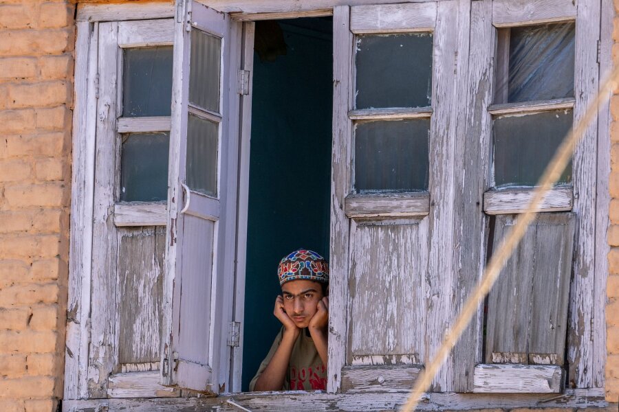 Bilder des Tages vom 09.05.2024 - Ein Junge aus Kaschmir beobachtet von einem Fenster seines Hauses aus eine Wahlkampfveranstaltung der Demokratischen Volkspartei von Jammu und Kaschmir. In Indien findet derzeit die Parlamentswahl statt, die ganze sechs Wochen dauert. 970 Millionen der 1,4 Milliarden Einwohner sind wahlberechtigt.