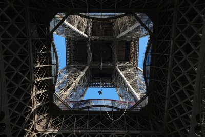 Bilder des Tages vom 10.04.2024 - Eiffelturm von unten: Sportler messen sich am Pariser Wahrzeichen im Seilklettern. Anouk Garnier ist hier auf dem Weg zur in 110 Meter gelegenen zweiten Etage des Turms.