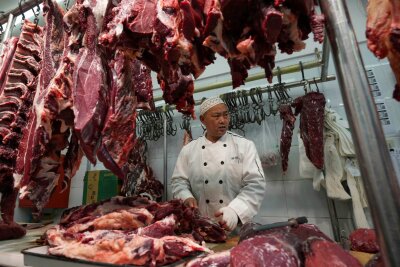 Bilder des Tages vom 10.04.2024 - Ein Metzger in der chinesischen Hauptstadt bereitet frisches Fleisch zu.