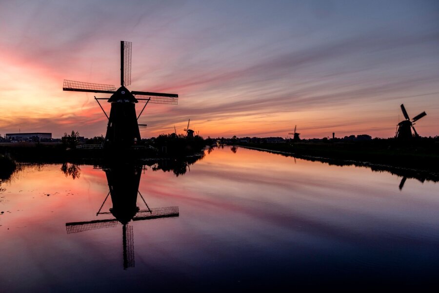 Bilder des Tages vom 12.05.2024 - Farbenspiel: Der Himmel hinter Windmühlen in Kinderdijk, Niederlande, ist bunt verfärbt. Die Windmühlen sind Teil von 19 Mühlen, die im 18. Jahrhundert südlich von Rotterdam gebaut wurden.