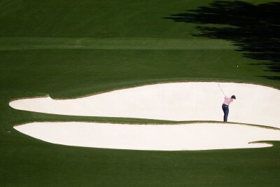 Bilder des Tages vom 13.04.2024 - Spannung in der Ferne: Der Golfspieler Rory McIlroy aus Nordirland schlägt am achten Loch. Seit 1934 findet das Golfturnier US Masters auf demselben Golfplatz in Georgia, USA statt.