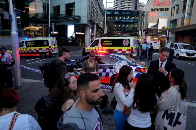 Bilder des Tages vom 13.04.2024 - Eine Menschenmenge versammelt sich vor dem Westfield Shopping Centre. Medienberichten zufolge wurden in dem Einkaufszentrum in Sydney mehrere Menschen niedergestochen und eine Person von der Polizei erschossen.