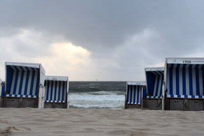 Bilder des Tages vom 14.04.2024 - Leere Strandkörbe vor aufgepeitschter Nordsee: Am Strand vor Westerland zeigt sich die Nordseeinsel Sylt von seiner stürmischen Seite.