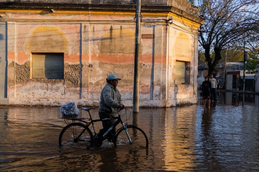 Bilder des Tages vom 14.05.2024 - Nicht nur Brasilien hat mit heftigen Regenfällen und Hochwasser zu kämpfen - auch das Nachbarland Uruguay ist betroffen. Dieser Mann watet durch die überfluteten Straßen in Paysandú im Westen des Landes.