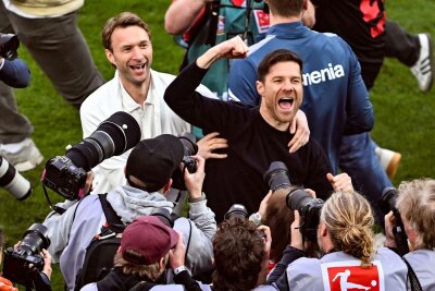 Bilder des Tages vom 15.04.2024 - Fußball: Leverkusens Trainer Xabi Alonso (r) und Sportchef Simon Rolfes jubeln über den Gewinn der deutschen Meisterschaft.
