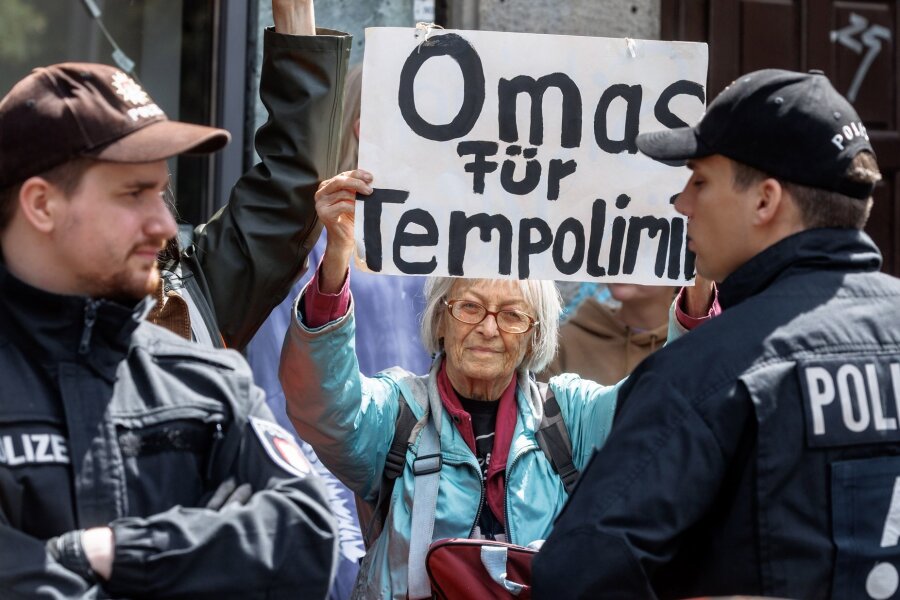 Bilder des Tages vom 15.06.2024 - Im Kampf für die Klimagerechtigkeit: Ein Mitglied der Letzten Generation zeigt ein Schild mit der Aufschrift "Omas für Tempolimit". Die Gruppe blockierte im Rahmen einer Protestaktion eine Straße im Hamburger Schanzenviertel.