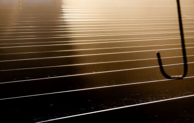 Bilder des Tages vom 17.04.2024 - Wie ein abstraktes Gemälde: Schienen im Güterbahnhof von Wismar reflektieren das Licht der aufgehenden Sonne.