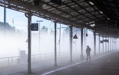 Bilder des Tages vom 17.04.2024 - Ein dunkler Schatten im Nebel. Kein Film. Ein Reisender wartet in Wismar auf den Zug.