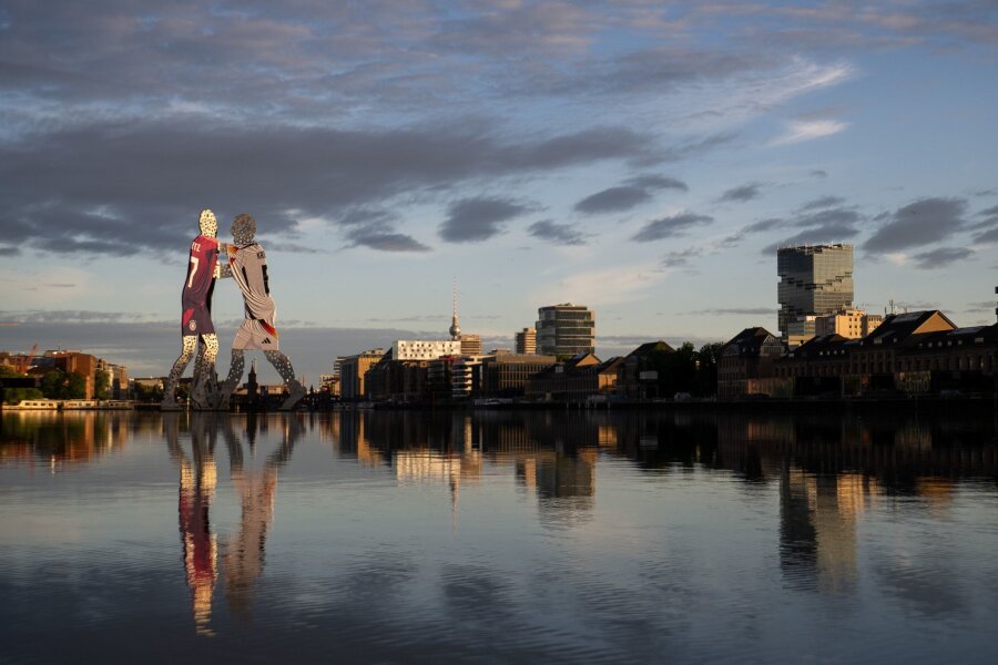 Bilder des Tages vom 17.06.2024 - Anlässlich der Fußball-Europameisterschaft im eigenen Land, tragen die beiden Männer der „Molecule Man“-Statue von US-Bildhauer Jonathan Borofsky, die in Berlin steht, Trikots der deutschen Herren-Nationalmannschaft.