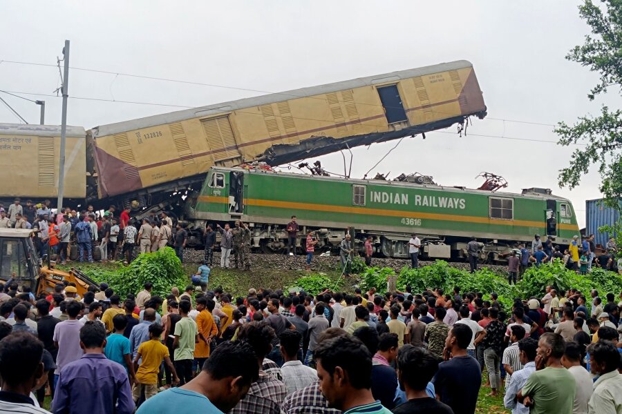 Bilder des Tages vom 17.06.2024 - Schaulustige beobachten die Arbeit von Rettungskräften, nachdem ein Güterzug in der Nähe des Bahnhofs von Neu Jalpaiguri einen Personenzug gerammt hat. 15 Menschen sind dabei ums Leben gekommen.