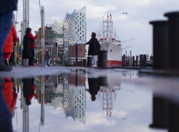 Bilder des Tages vom 18.04.2024 - Die Elbphilharmonie spiegelt sich an den Landungsbrücken im Hamburger Hafen.