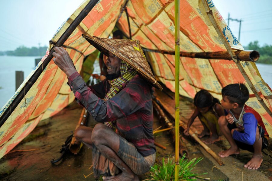 Bilder des Tages vom 18.06.2024 - Hochwasser in Bangladesch: Eine Familie stellt ein Zelt auf, um sich vor den Wassermassen zu schützen. Durch anhaltende Regenfälle und Erdrutsche ist die Region um Sylhet in Bangladesch überflutet.