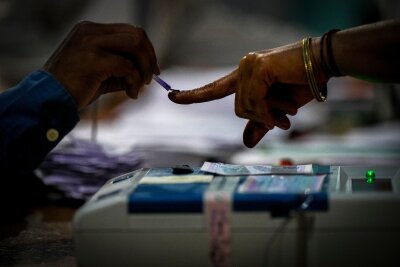 Bilder des Tages vom 19.04.2024 - Ein Wahlhelfer markiert den Zeigefinger einer Frau mit unauslöschlicher Tinte, als sie während der indischen Parlamentswahlen im Dorf Bahona im nordöstlichen Assam zur Stimmabgabe erscheint.