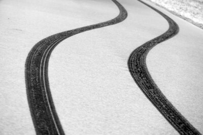 Bilder des Tages vom 21.04.2024 - Die Kurve gekriegt: Reifenspuren zeichnen sich auf einer Straße in Südbayern im Neuschnee ab.