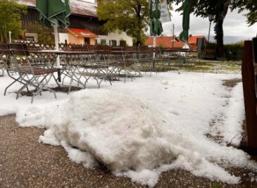 Bilder des Tages vom 23.05.2024 - Schnee Ende Mai? Nein, das sind die Folgen eines Unwetters in Bad Tölz. Hagel liegt auf der Terrasse eines Biergartens.