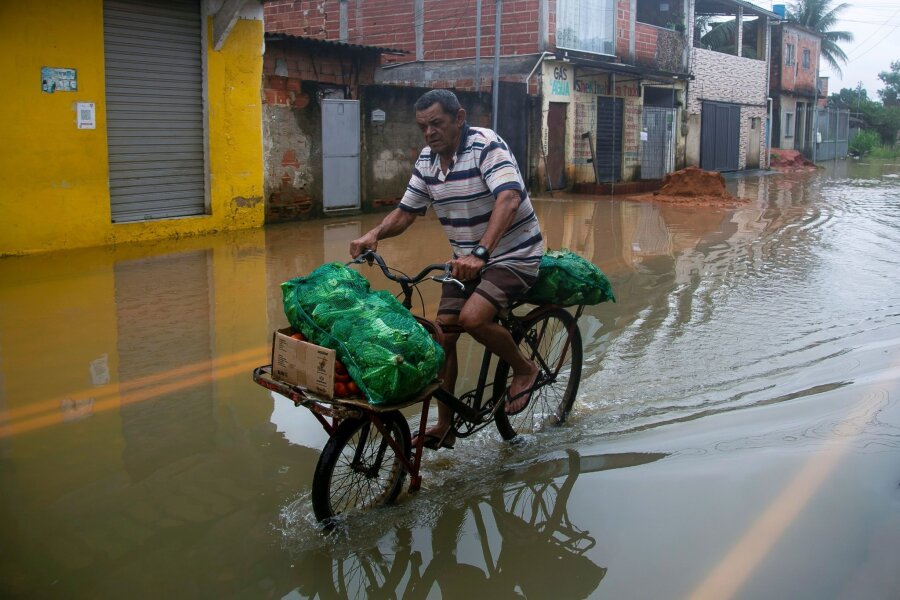 Bilder des Tages vom 24.03.2024 - Mit Kraft voran: Durch überflutete Straßen kämpft sich ein Mann auf seinem Fahrrad. 
Seit der Nacht zu Samstag verwüsteten schwere Unwetter und starke Regenfälle den Südosten Brasiliens, mindestens 23 Personen kamen ums Leben.